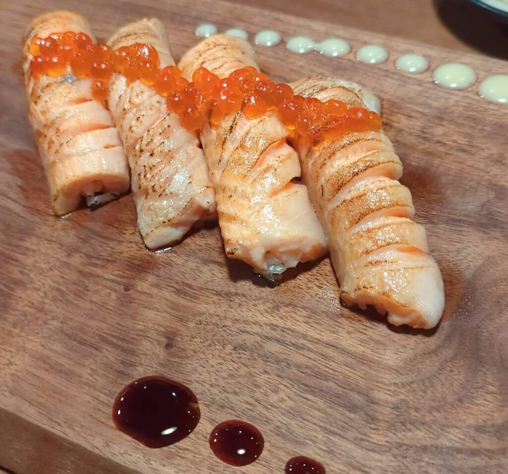 Seared Salmon Nigiri with Ikura from shinka sushi bar.